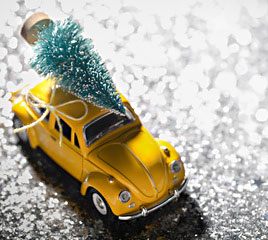 Miniaturauto transportiert Weihnachtsbaum